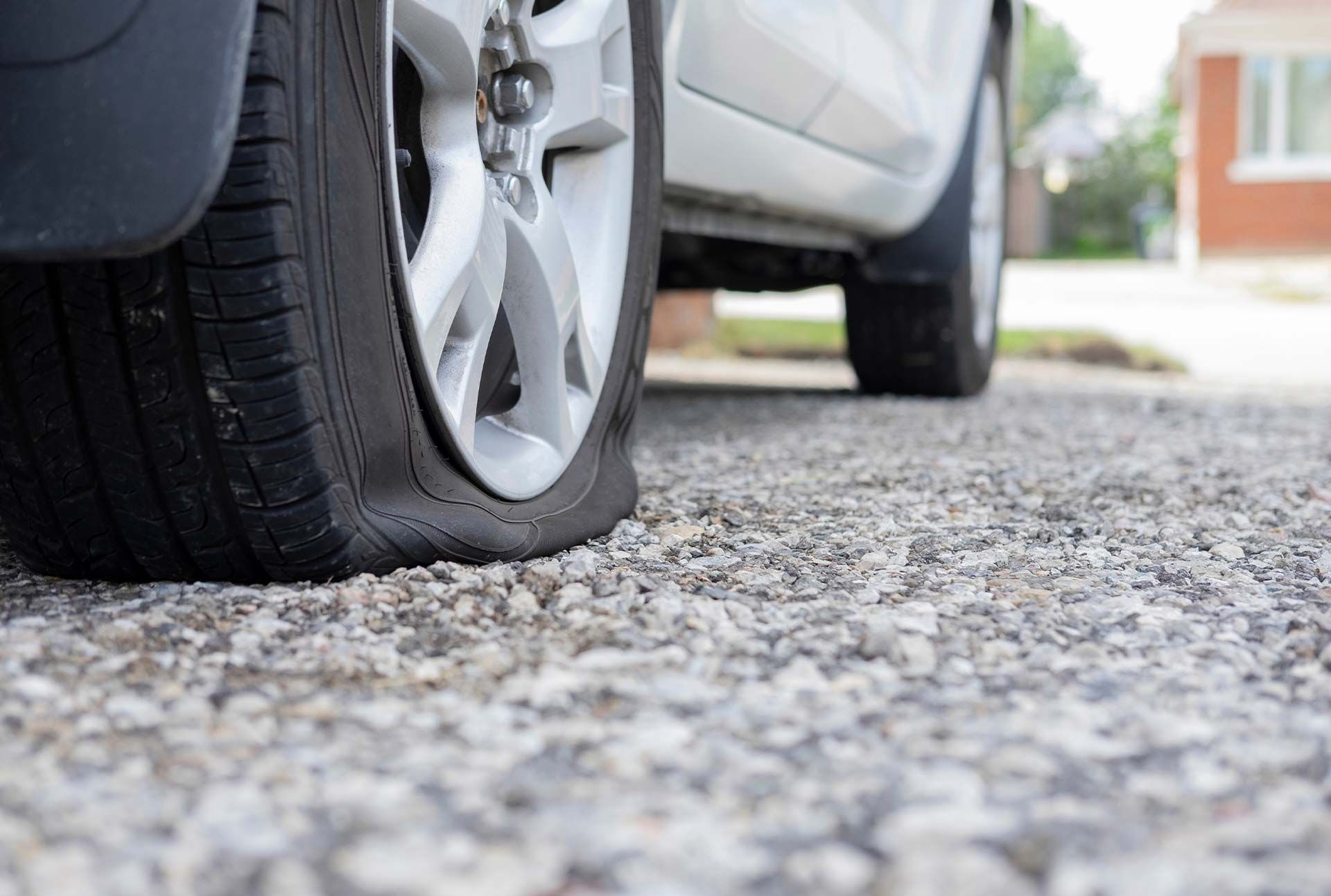 a car with a flat tire on a gravel road