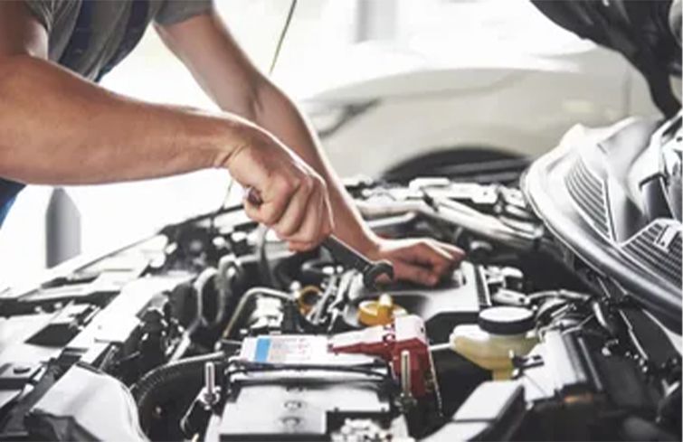 a man is working on the engine of a car .