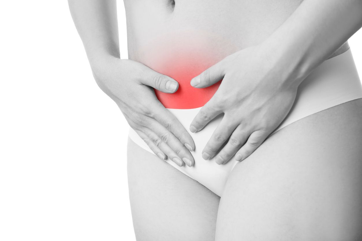 A woman is holding her stomach in pain.