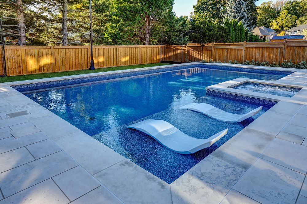 A large swimming pool with a wooden fence surrounding it.