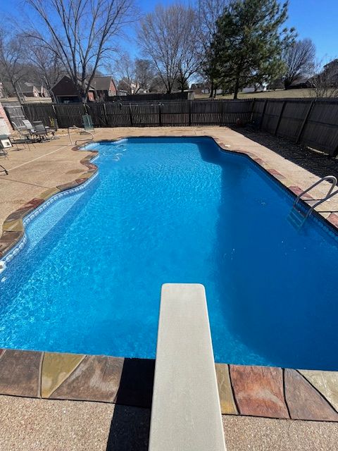 A large swimming pool with a diving board in the middle