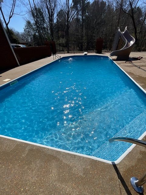 A large swimming pool with a slide in the background