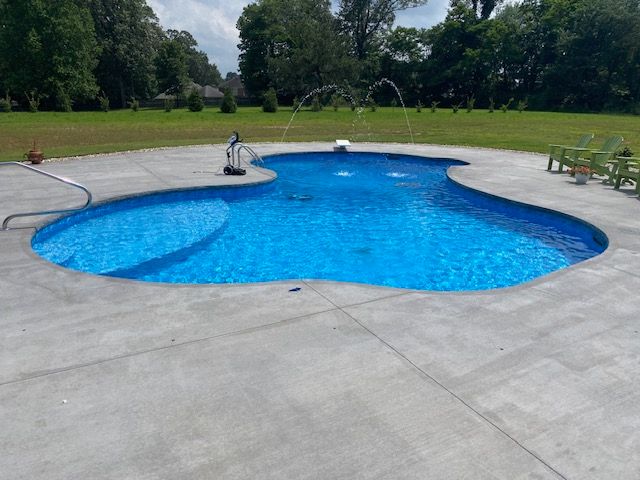 A large swimming pool with a fountain in the middle of it