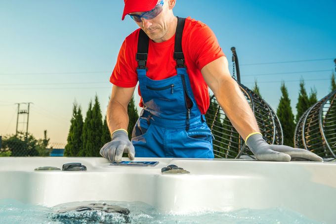 A man is working on a hot tub outside.