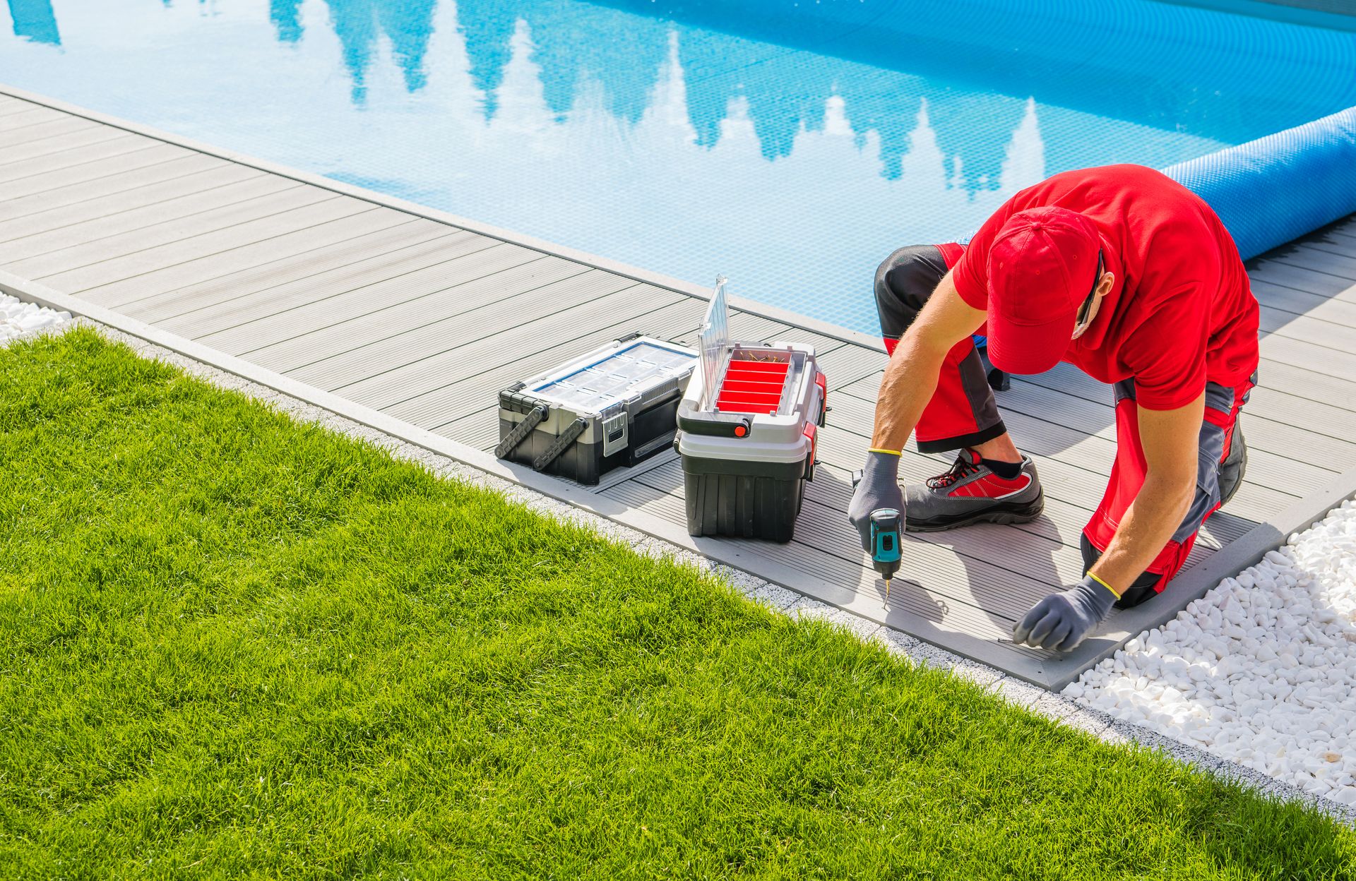 A man is working on the side of a swimming pool.