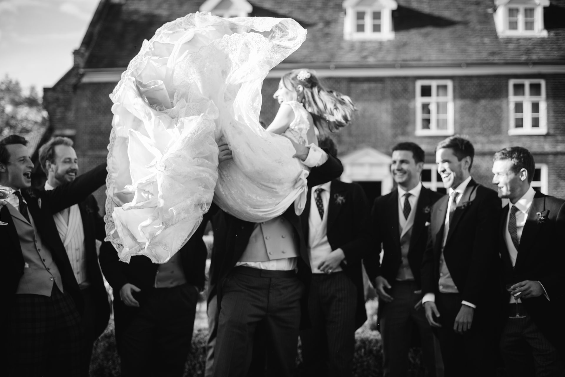 Bride and groom celebrating outdoors as guests cheer around them
