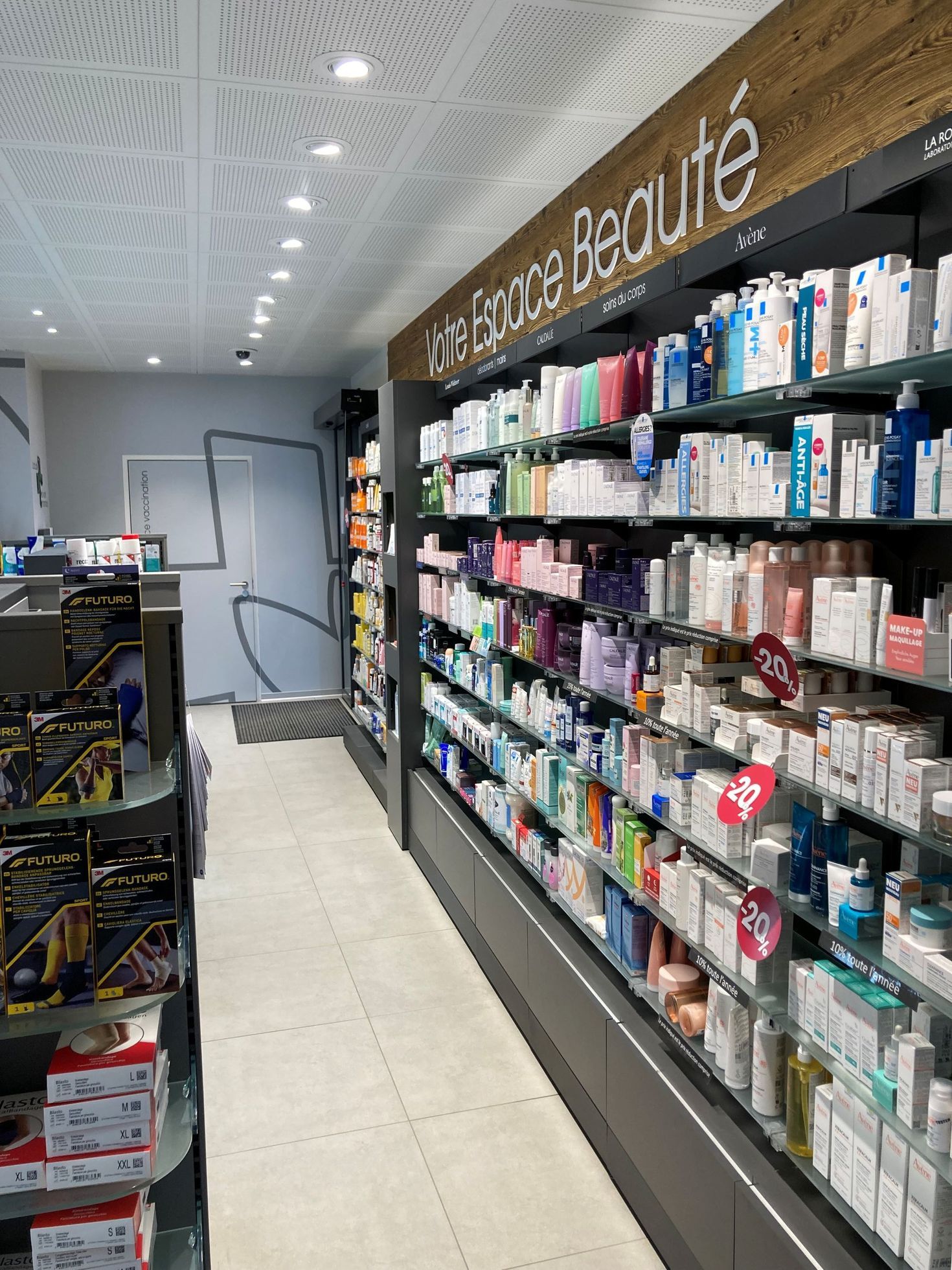 Shelves filled with various beauty and skincare products inside a brightly lit pharmacy store aisle.