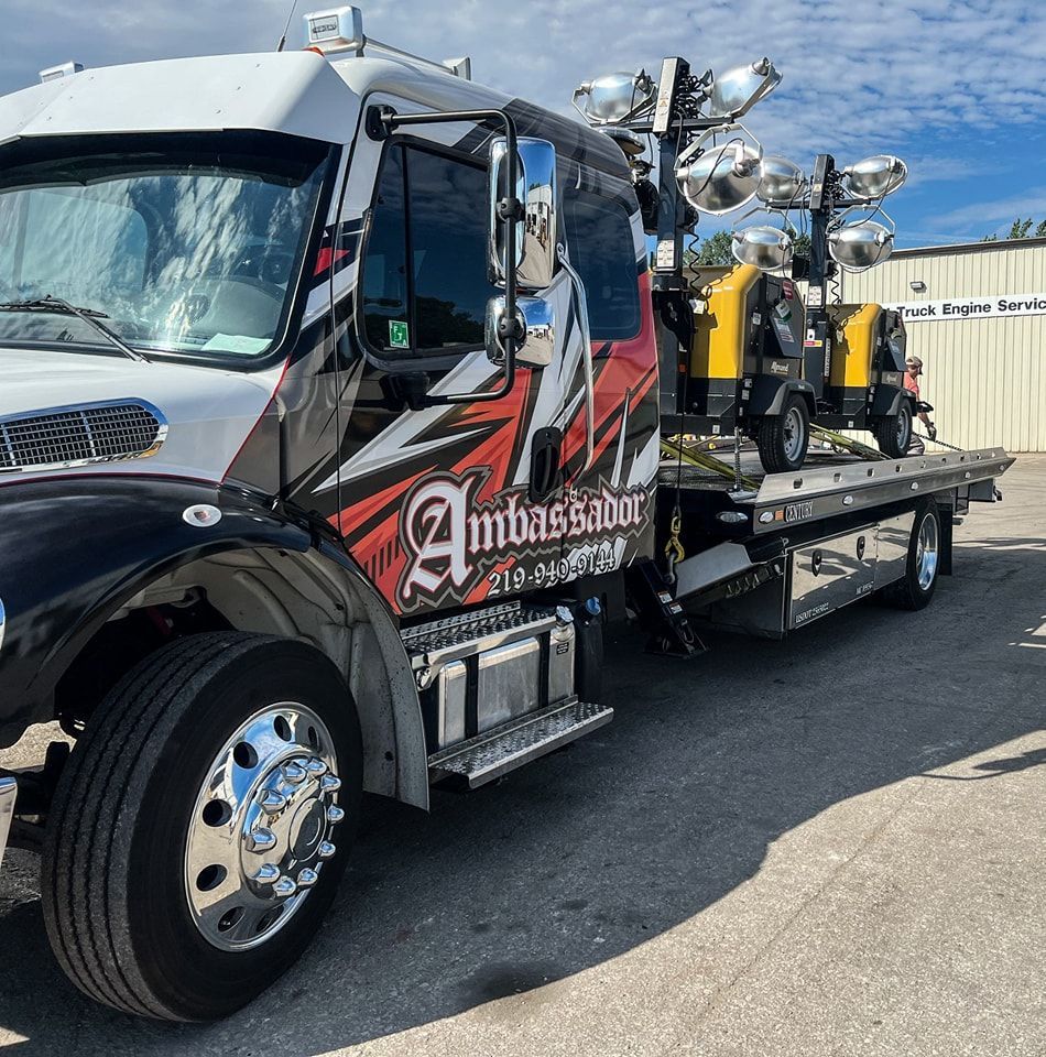 Tow truck with lights, Ambassador logo on the side.
