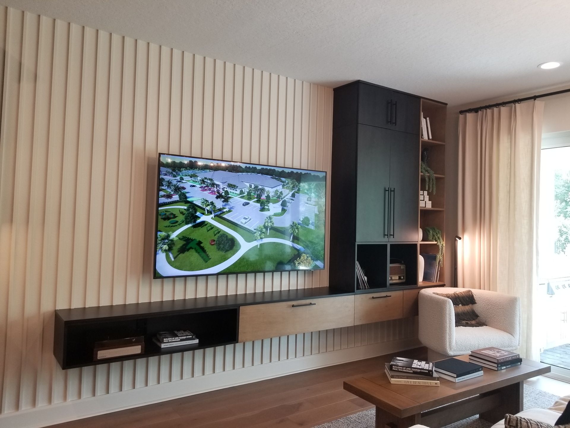 Modern living room with wall-mounted TV, vertical wood slat wall, and large window with sheer curtains