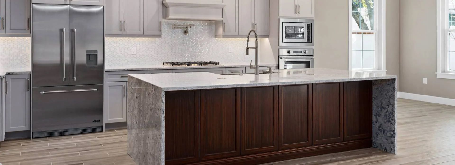 Modern kitchen with stainless steel fridge, white cabinets, and a dark wood island with marble countertop