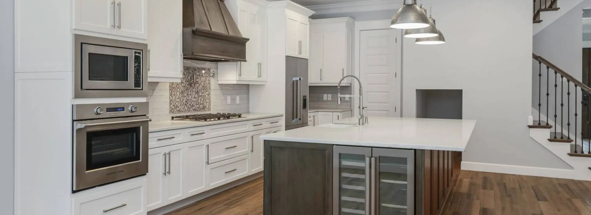 Bright modern kitchen with white cabinets, stainless appliances, and a large island.