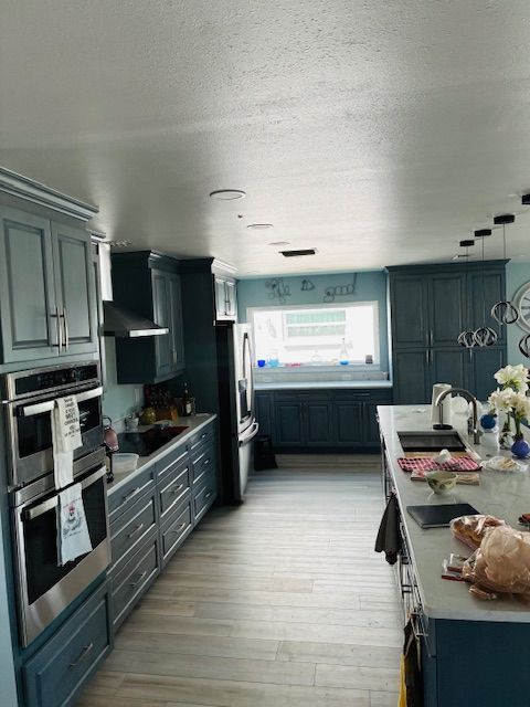 Modern kitchen with gray cabinets, central island, and window over the sink
