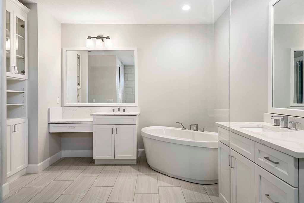 Bright white bathroom with vanity, mirror, shelving, and a freestanding bathtub