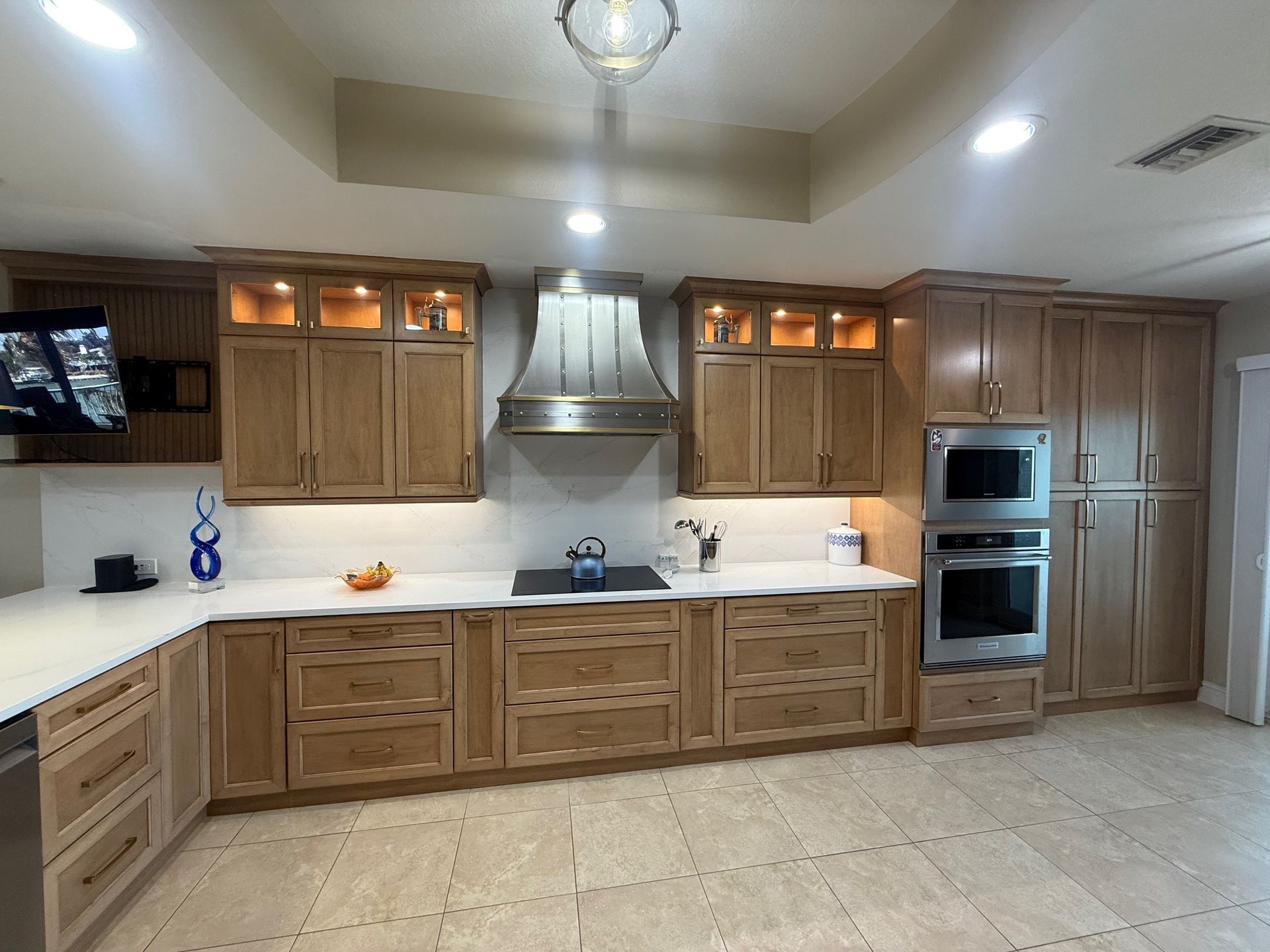 Spacious kitchen with wood cabinets, white countertops, stainless steel appliances, and beige tile floor