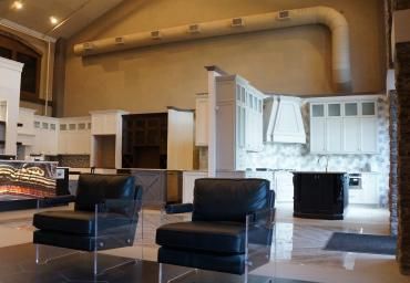 Modern living room with black chairs, fireplace, and large wall-mounted mechanical piping display