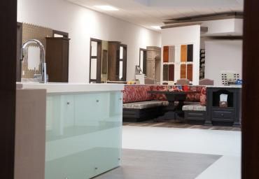 Modern living room with white tile floor, mint cabinet, red sofa, and black fireplace