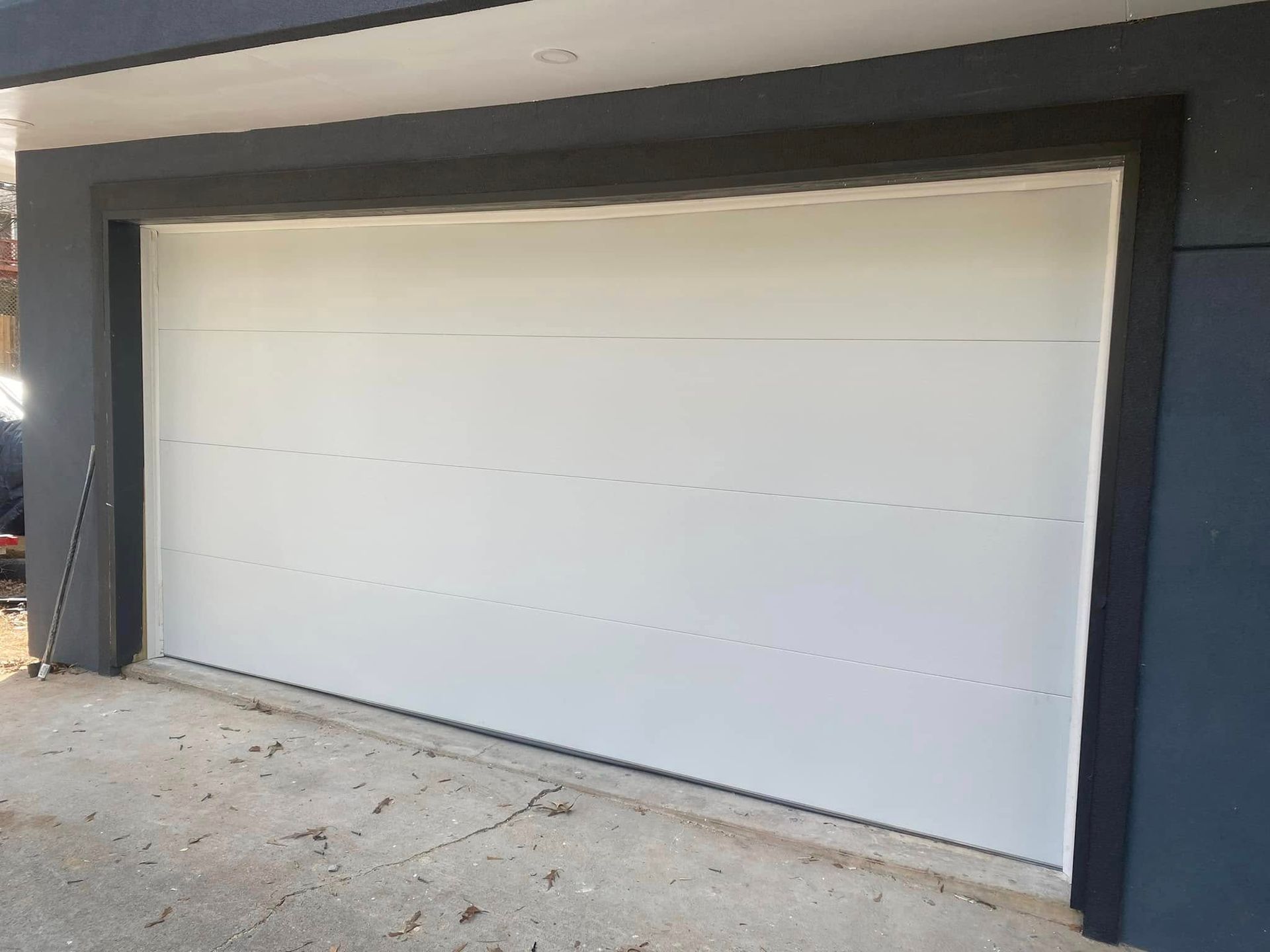 White garage door with black trim on a modern house exterior