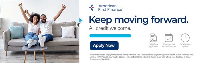 A couple celebrates on a sofa next to American First Finance branding,
