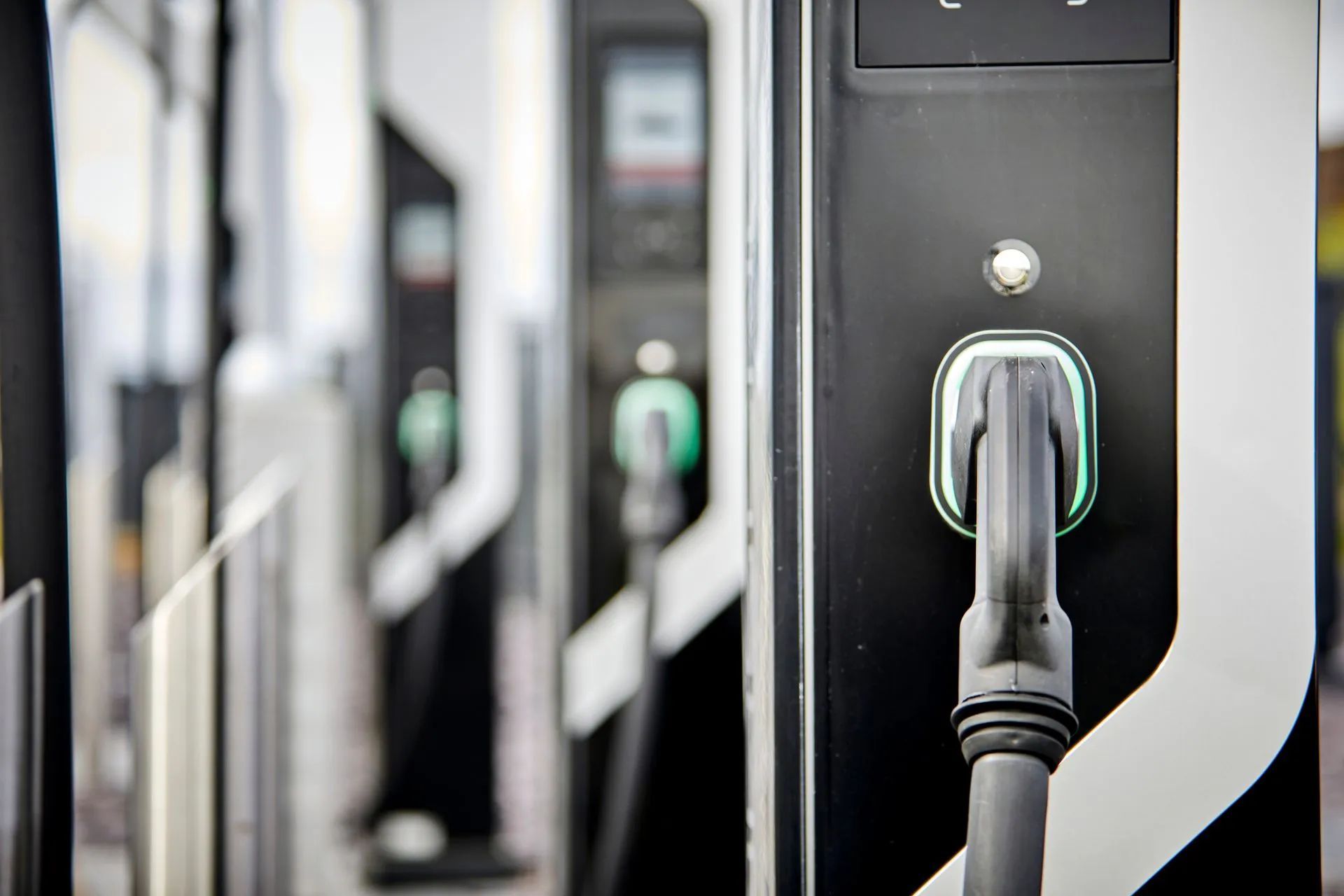 A close up of an electric car being charged at a charging station.