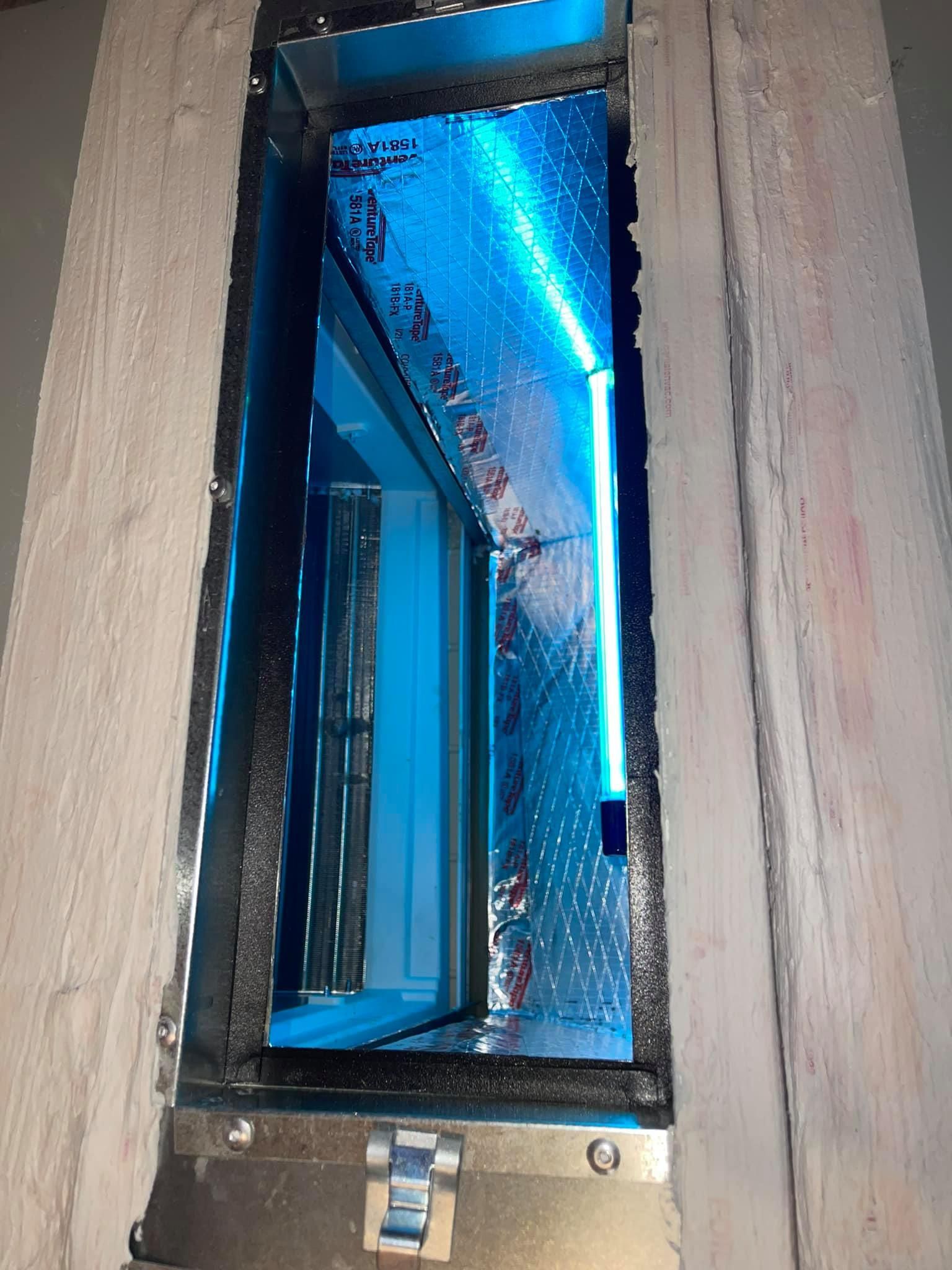 A blue light is shining through a hole in a wall.