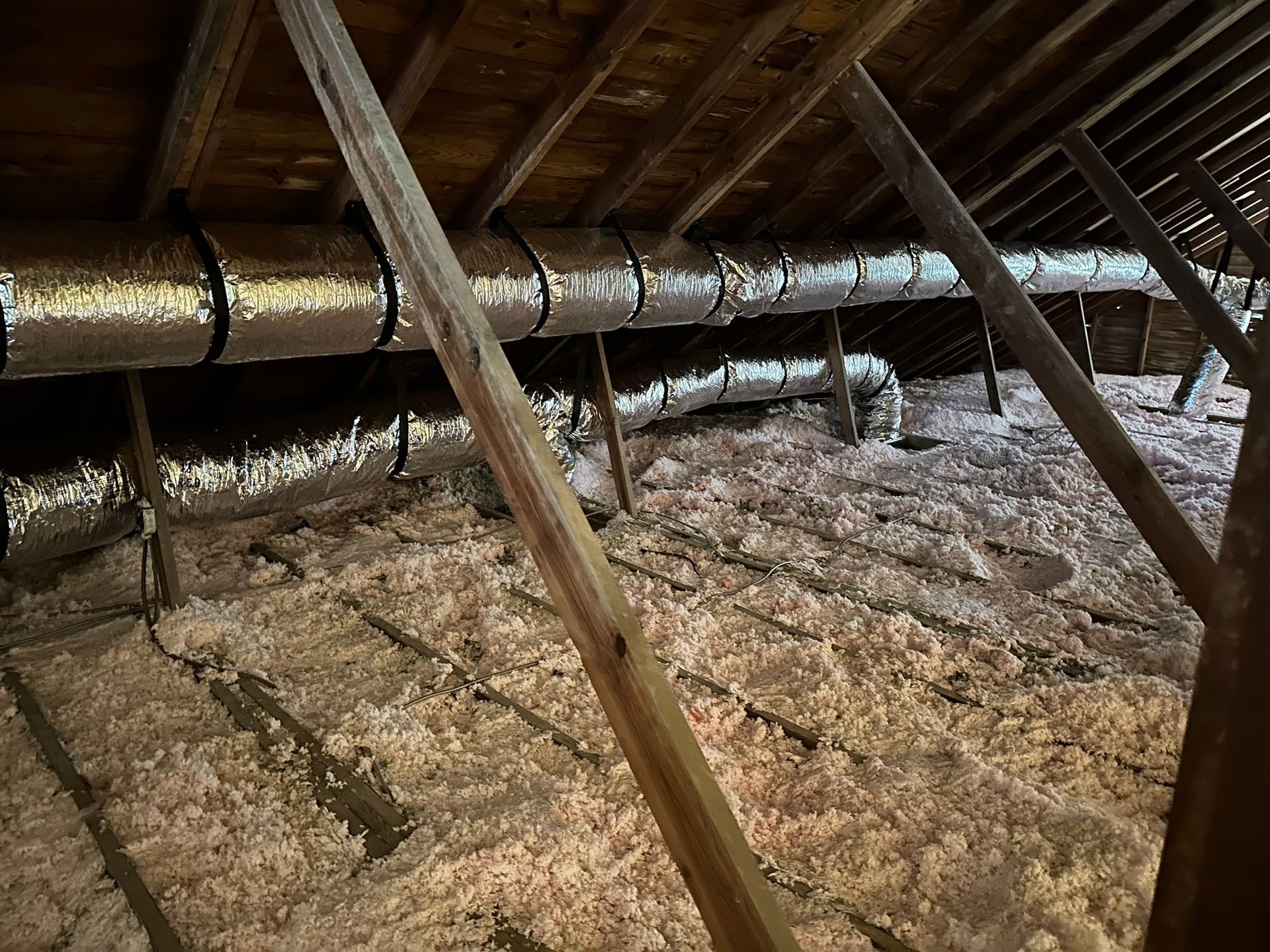 There is a lot of insulation in the attic of a house.