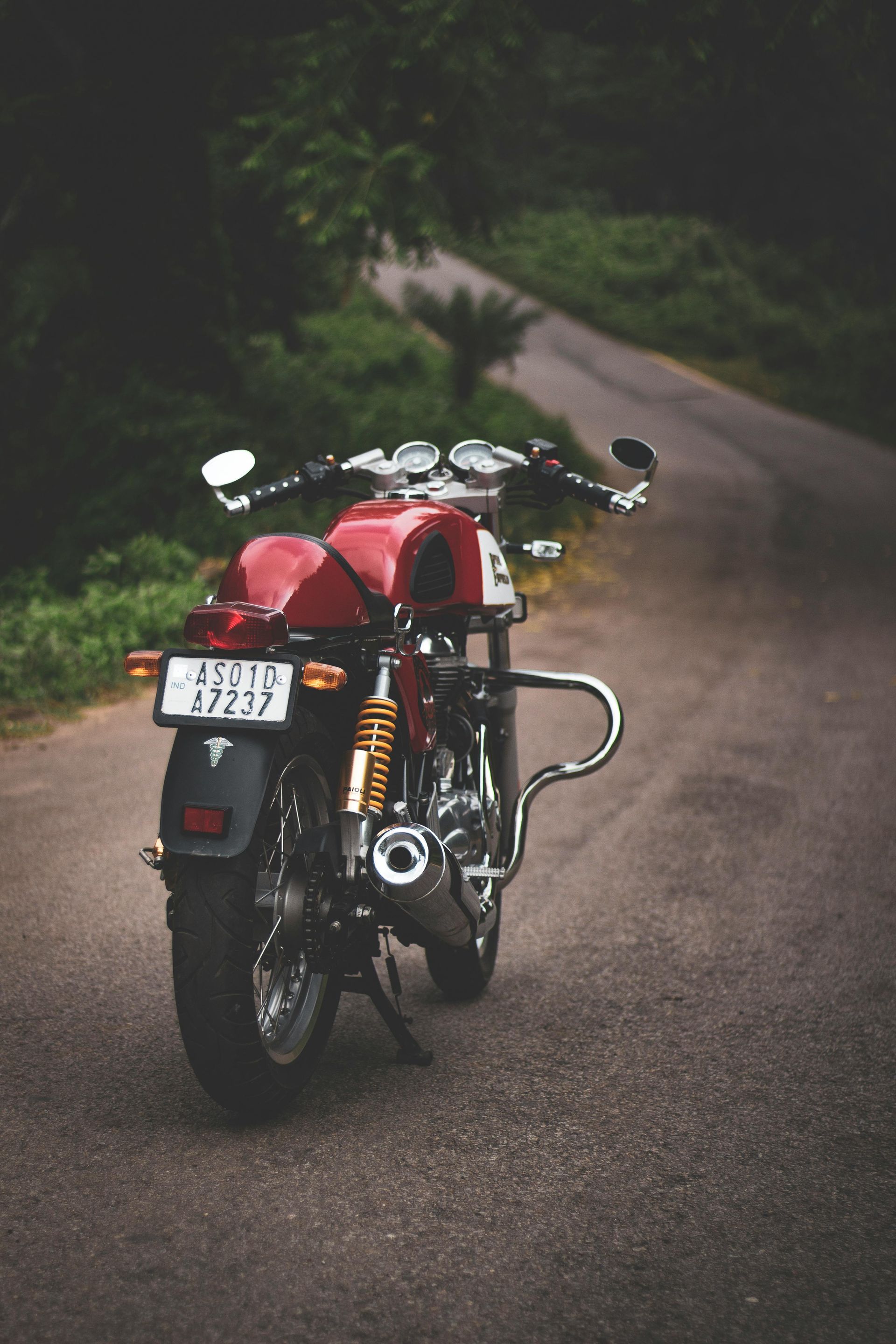 A red motorcycle is parked on the side of a road.