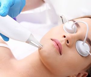 A woman is getting a laser treatment on her face.
