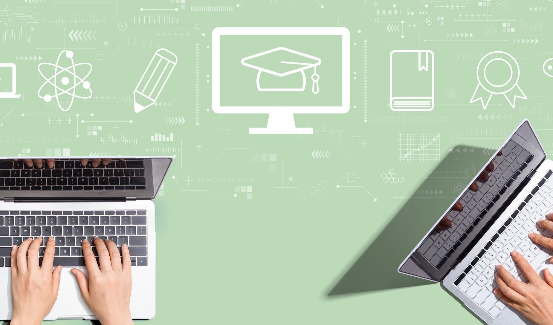 A person is typing on a laptop computer with a graduation cap on the screen.
