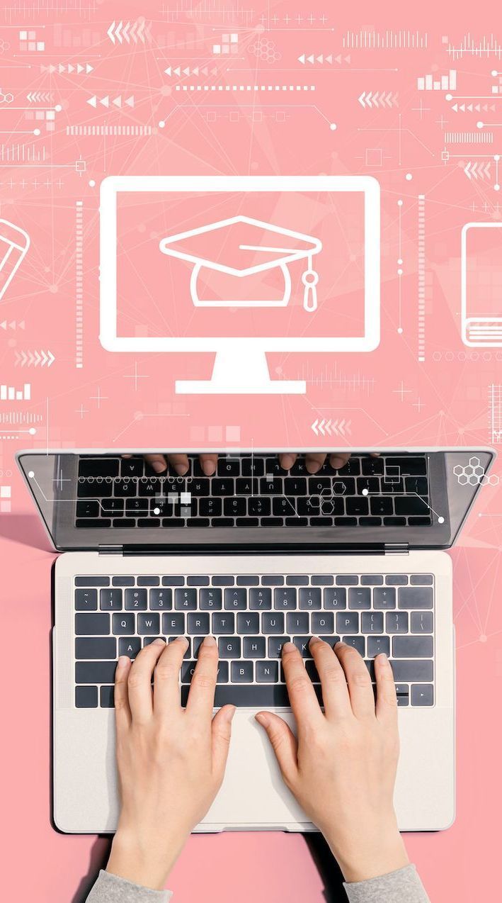 A person is typing on a laptop computer with a graduation cap on the screen.