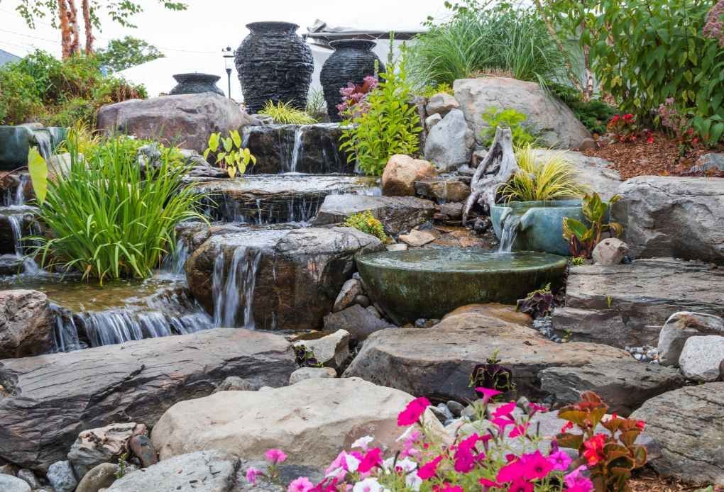 An image of resident's pondless waterfalls where water flows gracefully over rocks and stones.