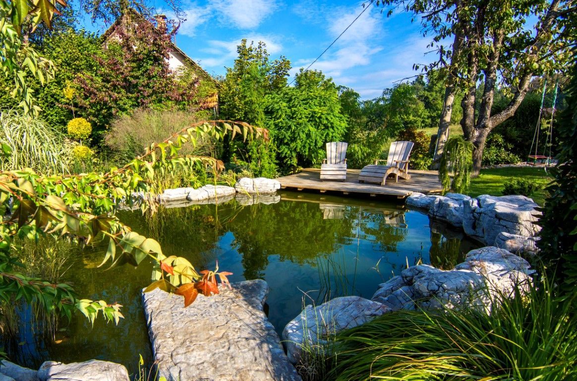 pair of wooden chairs on the deck above the pond