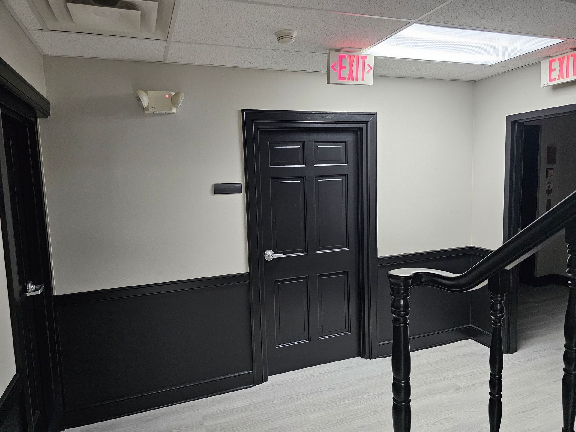 Hallway with black doors and trim, gray walls, and