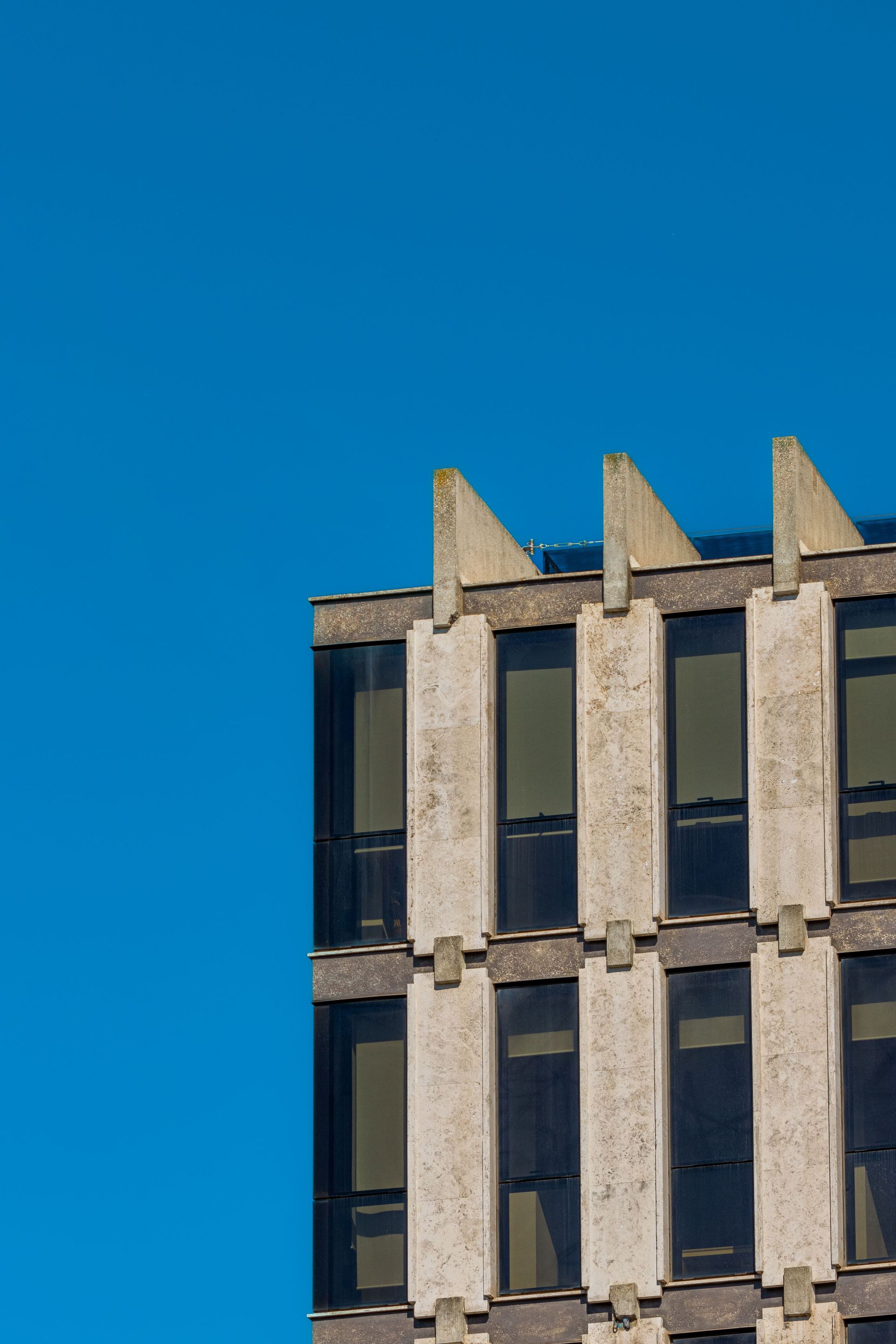 Concrete building facade against a clear blue sky