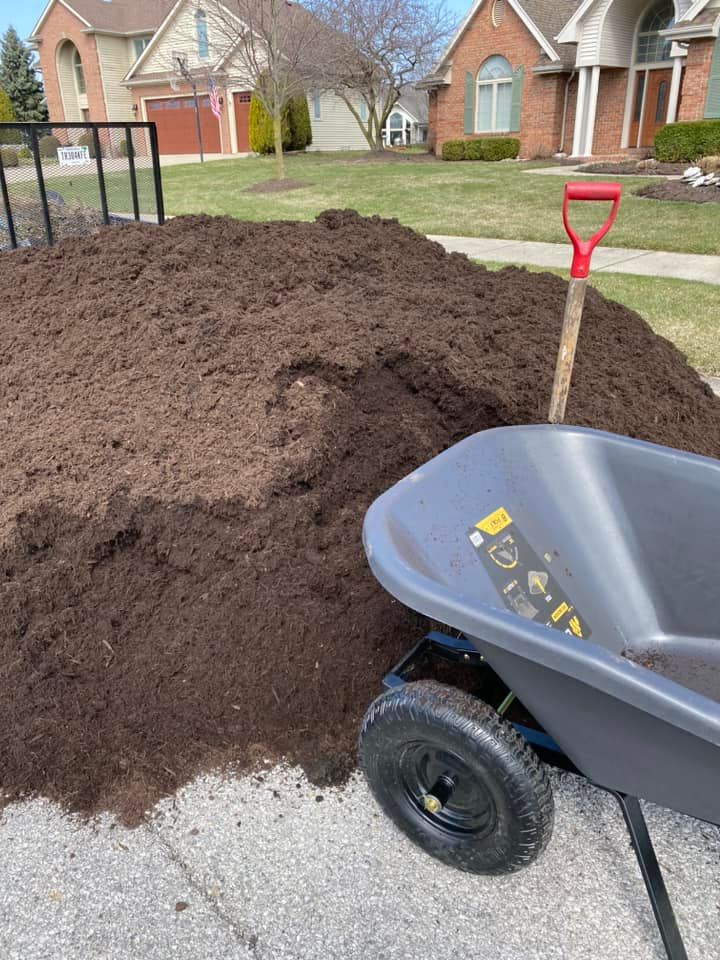 A pile of mulch and a wheel barrow