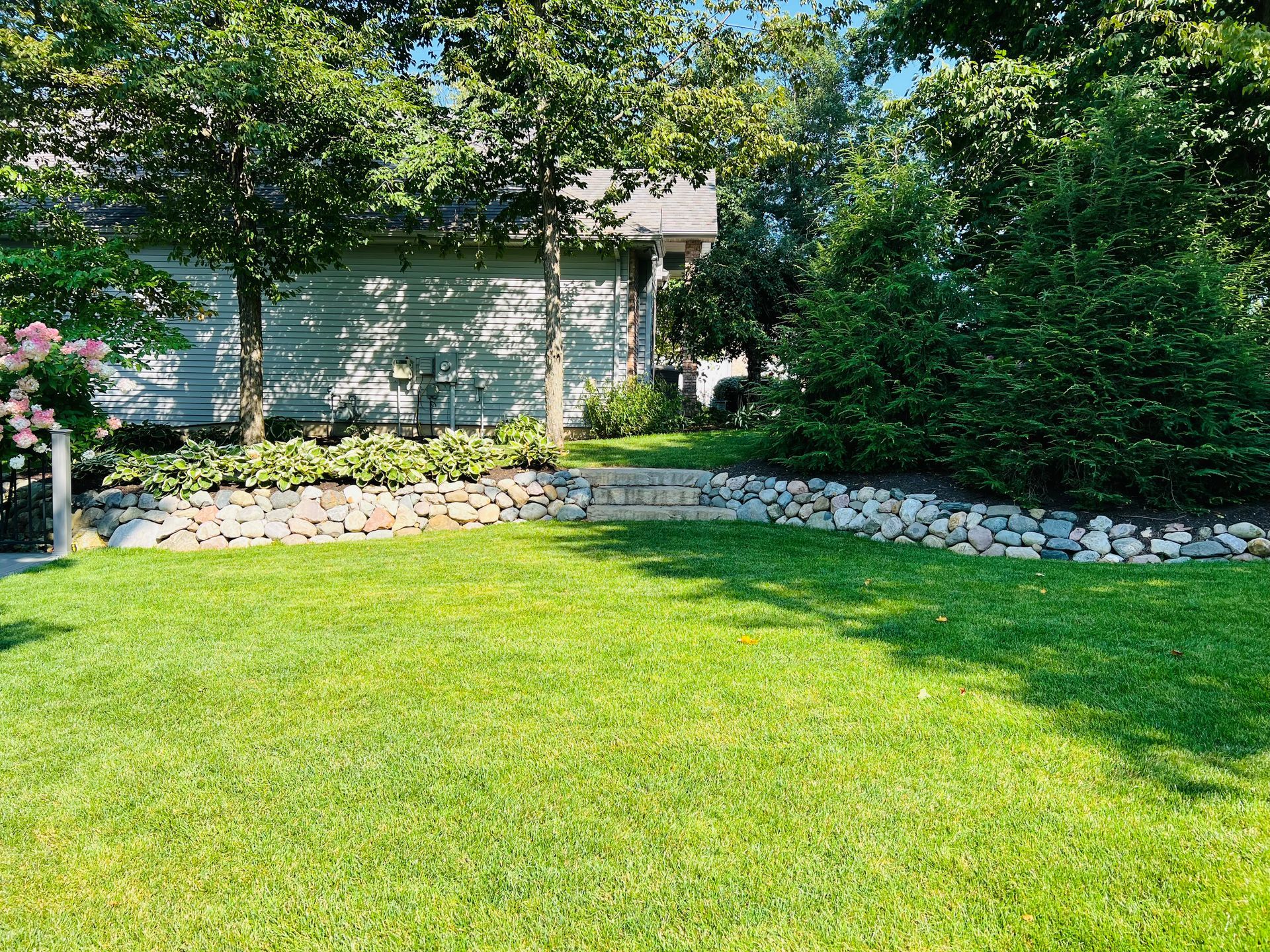 green yard with nicely done landscaping in backyard