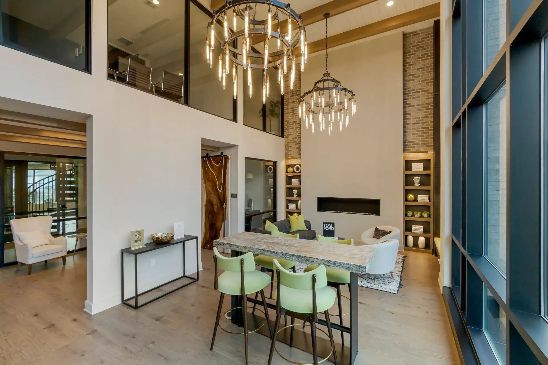 Interior view of a modern community lounge with chandeliers and large windows.