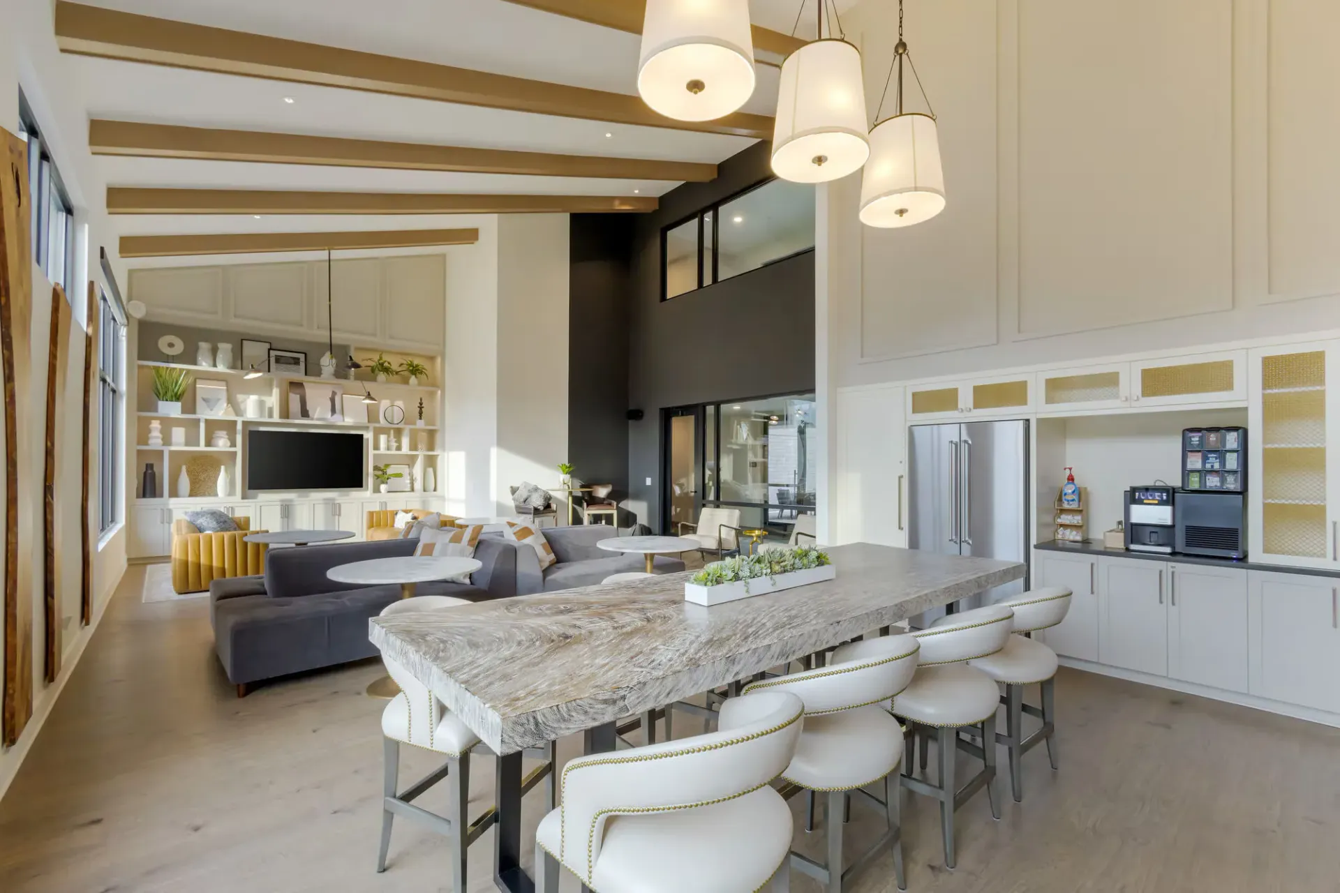 Open-concept community lounge and kitchen with a large island, seating, and built-in shelving.