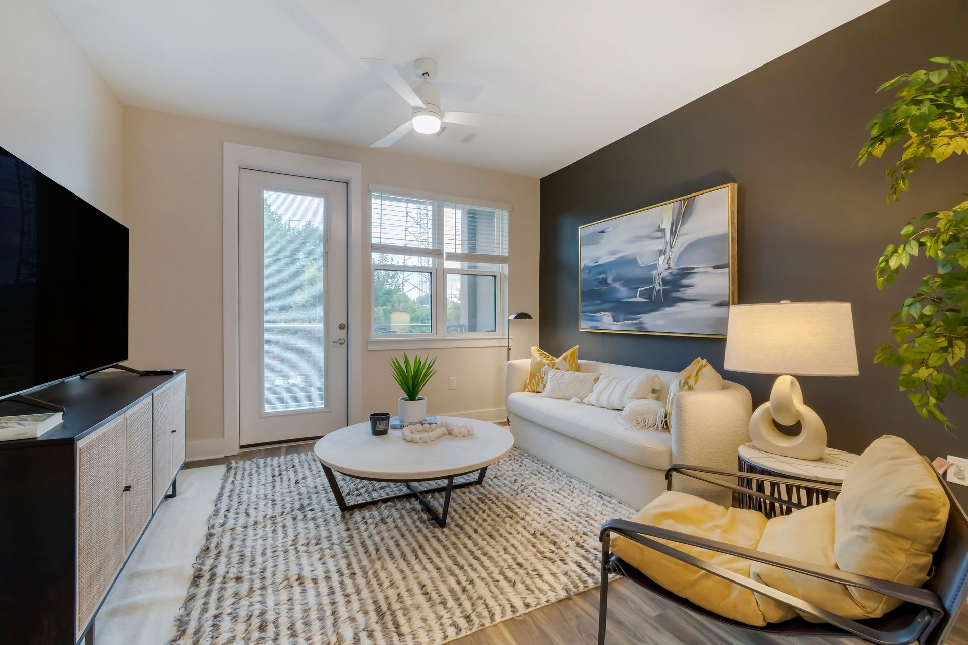 Living room with white sofa, black accent wall, and wooden furniture.