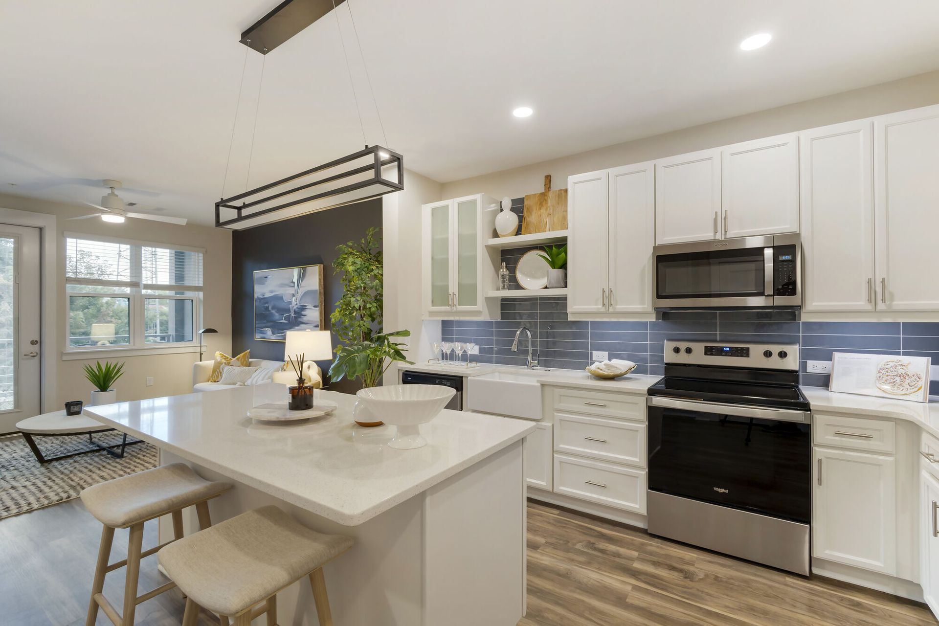Open-concept kitchen with white cabinets, an island, and stainless-steel appliances.