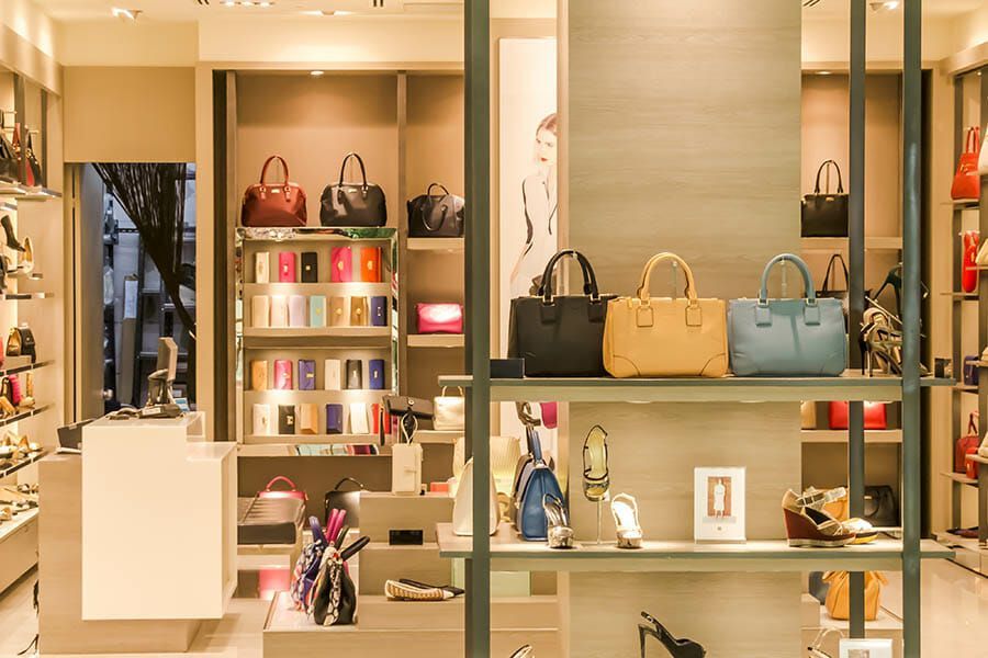 A store filled with lots of bags and shoes on shelves.