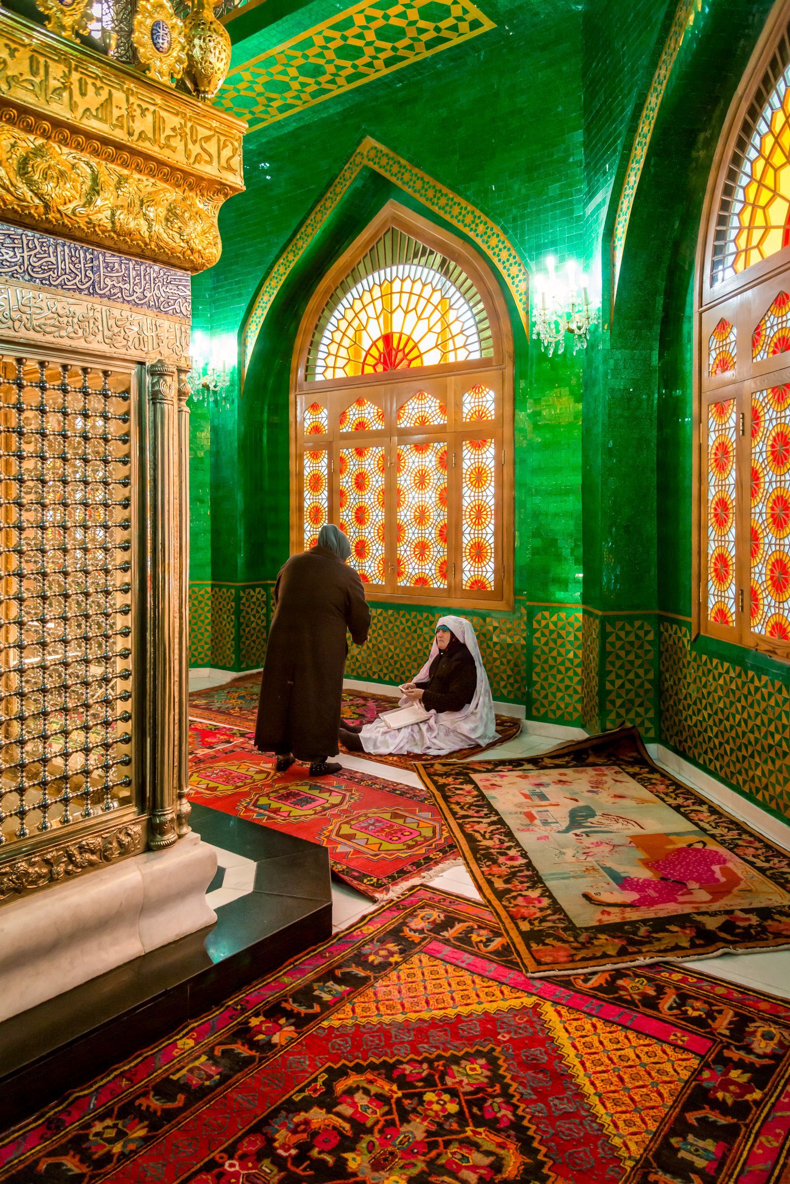 A man and a woman are praying in a mosque.