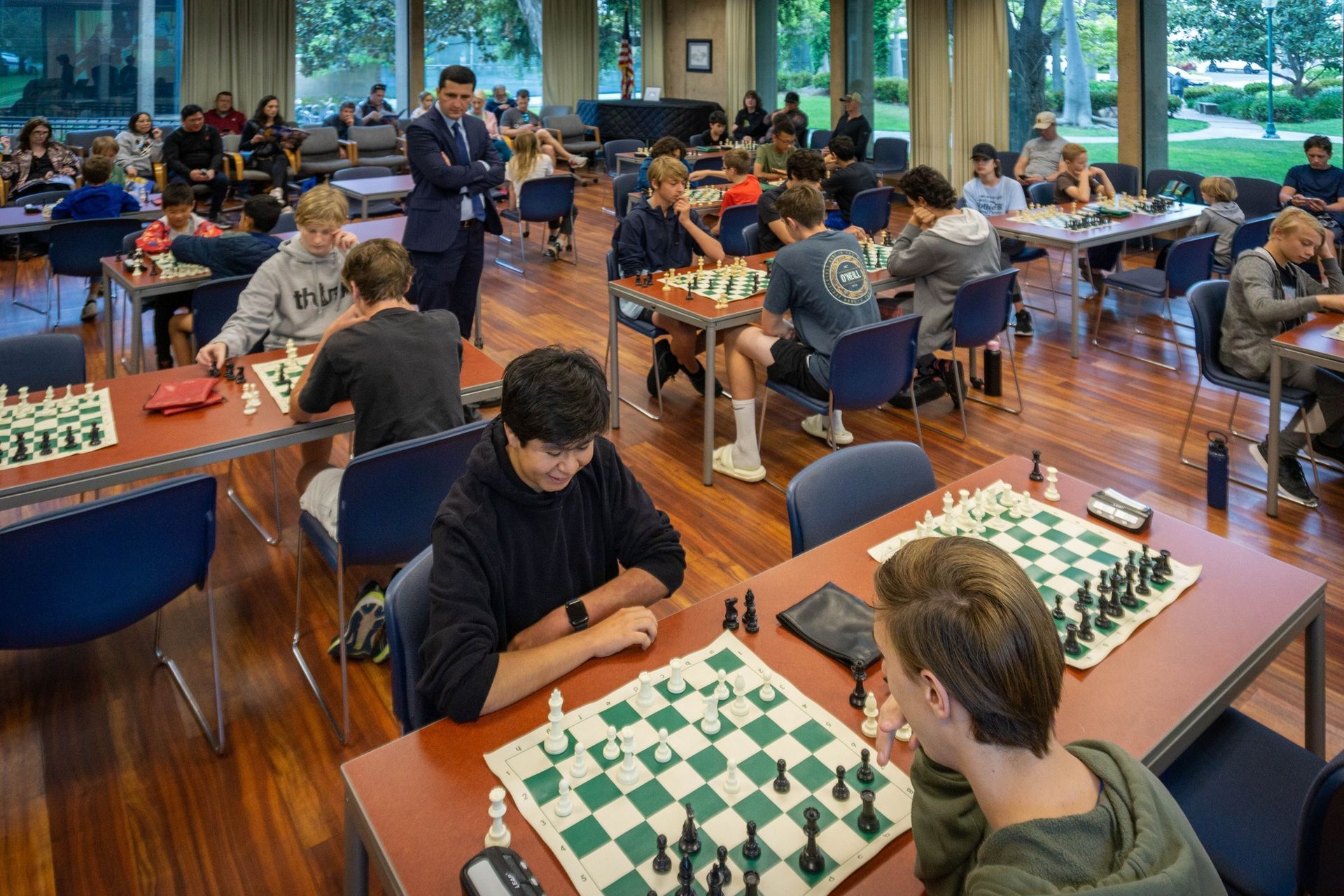 A group of people are playing chess in a room.