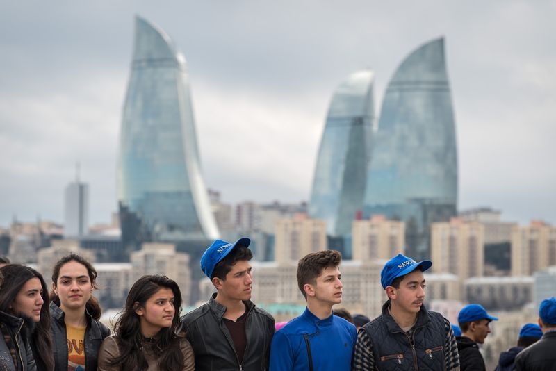 A group of young people are standing in front of a city skyline.