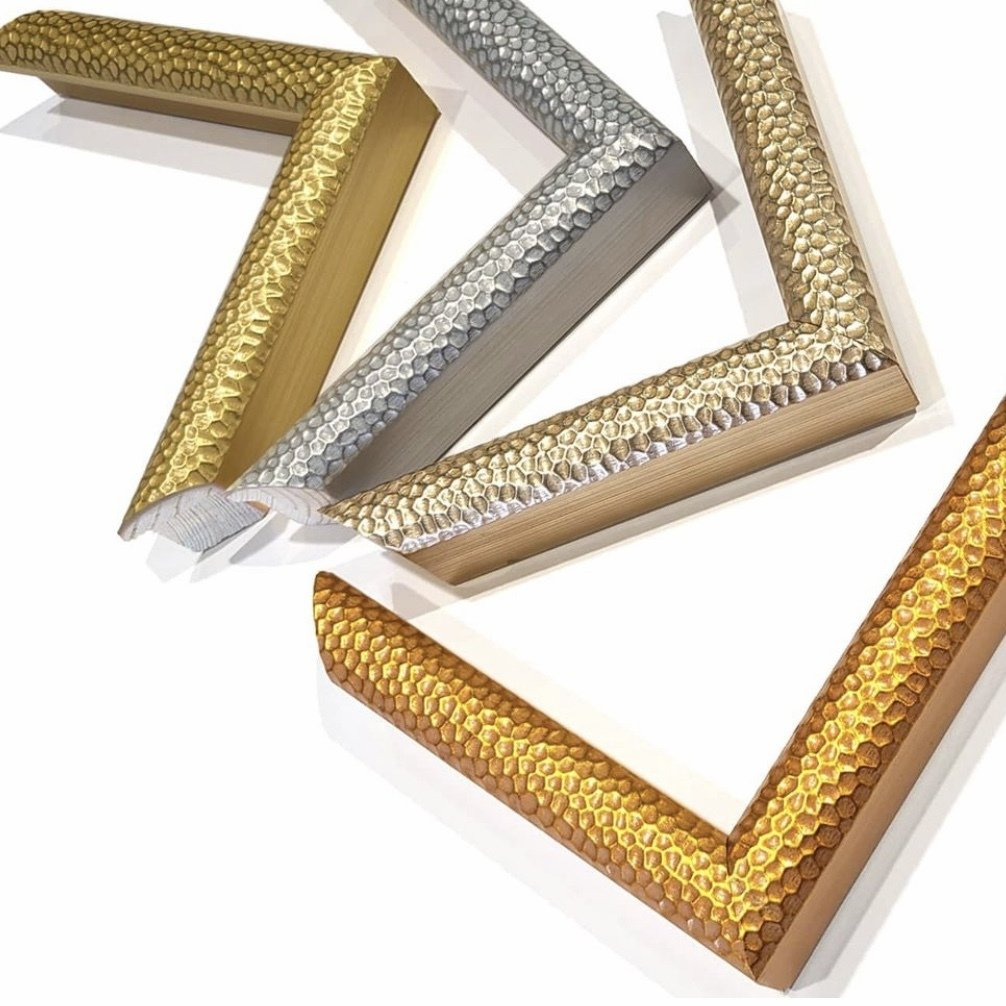 Four L-shaped corner samples of ornate picture frames in gold and silver finishes, arranged on a white background.