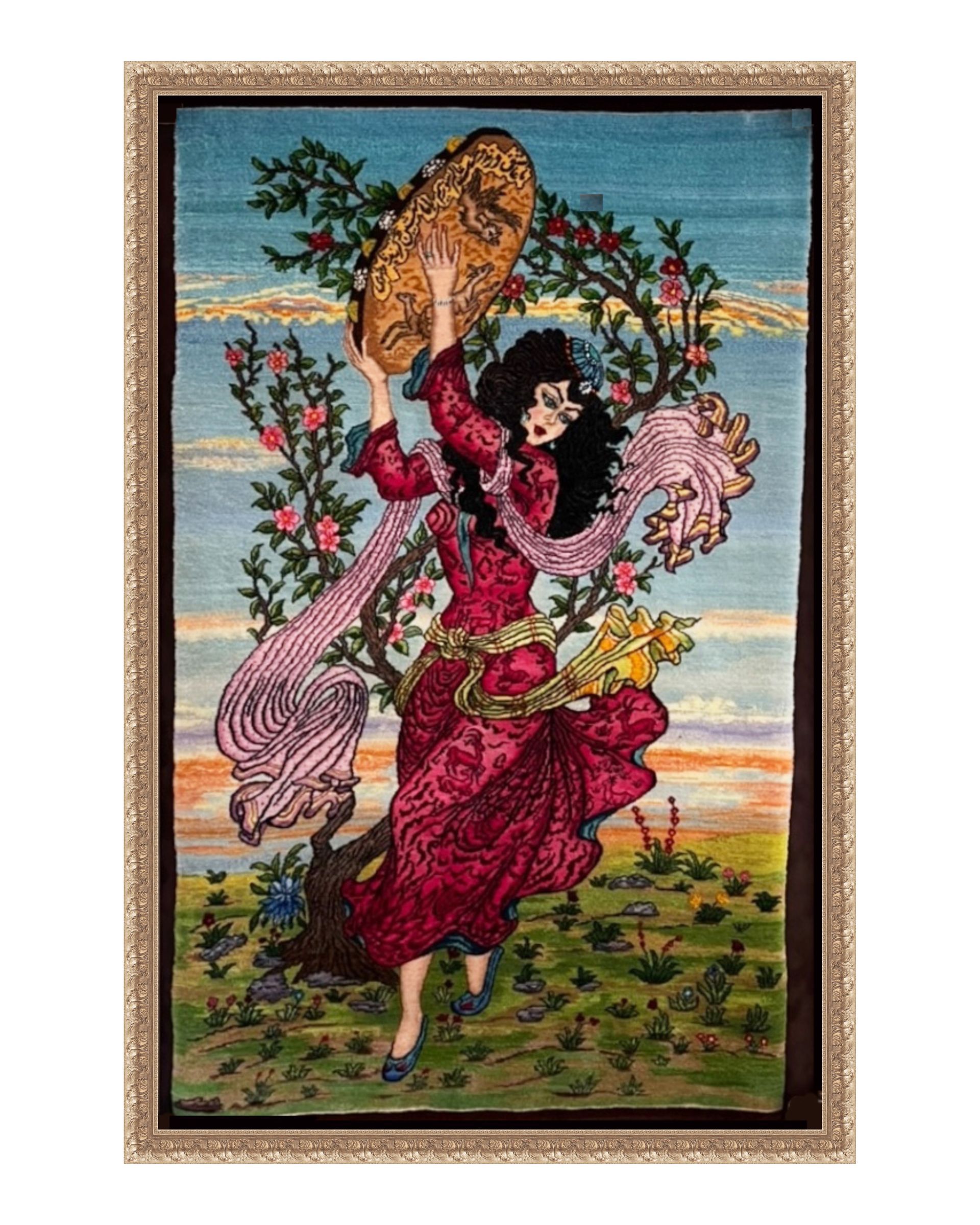 A framed tapestry shows a figure in a flowing red dress dancing in a field while holding a tambourine aloft.