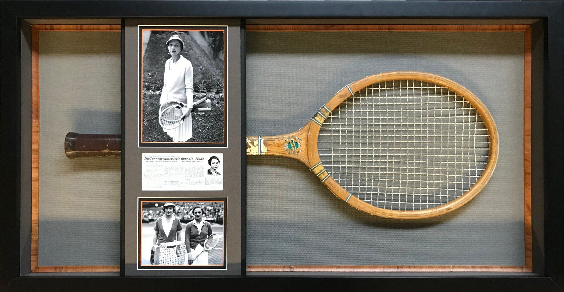 A vintage wooden tennis racket framed with two historical photographs and a descriptive plaque.
