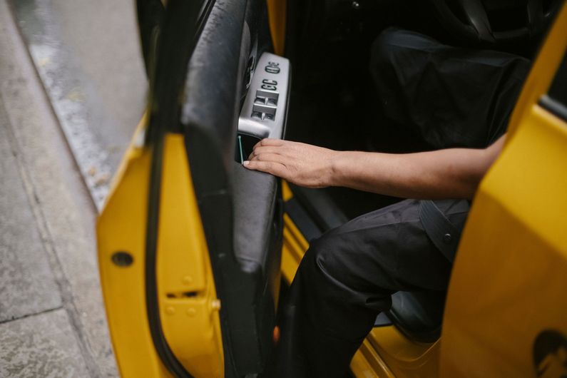 Person reaching for the control panel inside a yellow vehicle door
