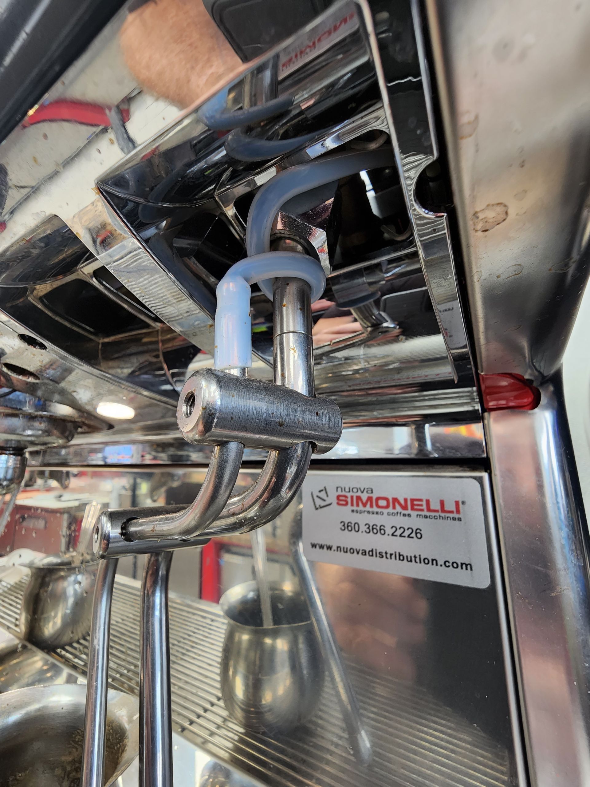 Under-seat plumbing and tubing on a stainless steel commercial machine with a BIMONELLI label