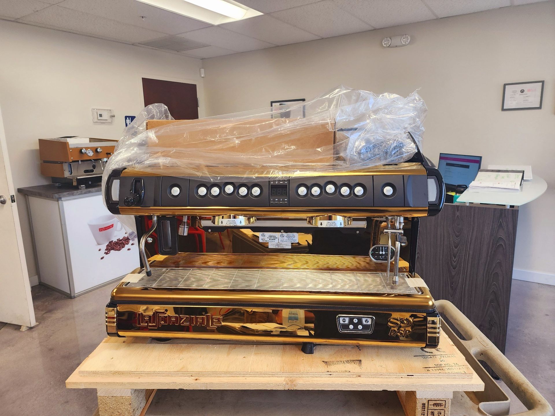 Two stacked audio components on a pallet in a warehouse, with protective wrapping on top.