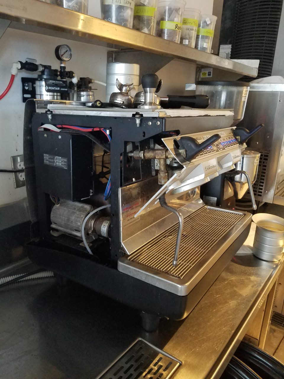 Espresso machine on a café counter with cups and tools beside it